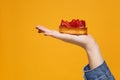 Close up cropped photo of female hold in hand strawberry cake isolated on yellow orange wall background. Copy space Royalty Free Stock Photo