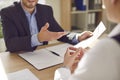 Two company employees sitting in office looking through documents on workplace. Royalty Free Stock Photo