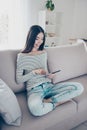 Close up cropped photo of young cheerful chinese lady browsing on her tablet, sitting on beige couch indoors at home, wearing casu Royalty Free Stock Photo