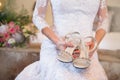 Bride holding her silver gem stone wedding shoes