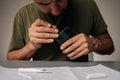 Close-up cropped shot of technician cleaning smartphone using specialized tools sitting at table, ensuring optimal Royalty Free Stock Photo