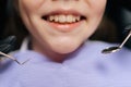 Close-up cropped shot of unrecognizable cheerful cute little girl sitting in stomatology seat while pediatric dentist Royalty Free Stock Photo