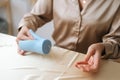 Close-up cropped shot of unrecognizable female artisan putting wick through silicone mold preparing for pouring liquid