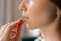 Close-up cropped shot of unrecognizable ill young woman taking pill. Closeup side view of depressed redhead female Royalty Free Stock Photo