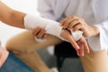 Close-up cropped shot of unrecognizable male doctor examination injured female patient with broken hand wrapped in Royalty Free Stock Photo