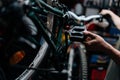 Close-up cropped shot of unrecognizable repairman holding the pedal of bicycle, insisting speed switches on mountain