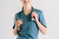 Close-up cropped shot of unrecognizable smiling female physician in green medical uniform with stethoscope around neck. Royalty Free Stock Photo