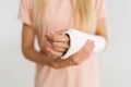 Close-up cropped shot of unrecognizable young woman with broken arm wrapped in plaster bandage gently touching forearm Royalty Free Stock Photo