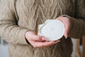 Close-up cropped shot of unrecognizable young woman holding scented handmade candle in candlestick made of exotic Royalty Free Stock Photo