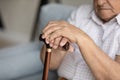 Close up cropped view disabled older man holds walking stick