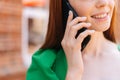 Close-up of attractive young woman talking on mobile phone walking on city street in sunny summer day Royalty Free Stock Photo