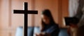 Close up cross is blur background. Asian Christian woman and man holding hands in praying for Jesus` blessings to show love and Royalty Free Stock Photo