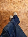 Close up of crossed legs with jeans and white shoes Royalty Free Stock Photo