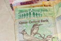 A close up of the  crrency of Qatar or  the Qatari Riyal notes of cash spread out on the white background. Money exchange Royalty Free Stock Photo