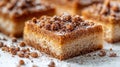Close-up of a crumble topping square cake on a white surface with more cakes in the background Royalty Free Stock Photo