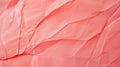 Close-up of a crumpled pink paper texture with soft shadows and light variations creating a gentle, tactile surface