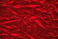 Close-up of crumpled silver aluminum foil texture in red tone. Abstract background for design. Royalty Free Stock Photo