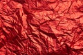 Close-up of crumpled silver aluminum foil texture in red tone. Abstract background, use for design. Royalty Free Stock Photo