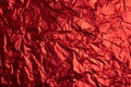 Close-up of crumpled silver aluminum foil texture in red tone. Abstract background, use for design. Royalty Free Stock Photo