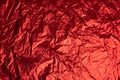 Close-up of crumpled silver aluminum foil texture in red tone. Abstract background, use for design. Royalty Free Stock Photo