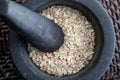 Close-up with crushed whole oats. In stone mortar. Royalty Free Stock Photo