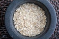 Close-up with crushed whole oats. In stone mortar.
