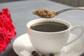 A Cup of black coffee on the table, a bouquet of red roses Royalty Free Stock Photo