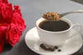 A Cup of black coffee on the table, a bouquet of red roses Royalty Free Stock Photo