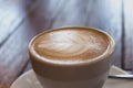 Close up of a cup of coffee latte on wooden table in coffee shop Royalty Free Stock Photo