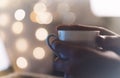 Close-up cup of coffee or tea in hipster girl hands on background relax glitter xmas decoration with an open laptop in home Royalty Free Stock Photo