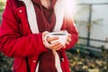 Close up of cup of coffee in woman's hands. Unrecognizable female holds hot mug of drink, standing in garden. Royalty Free Stock Photo