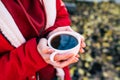 Close up of cup of coffee in woman& x27;s hands. Unrecognizable female holds hot mug of drink, standing in garden. Royalty Free Stock Photo