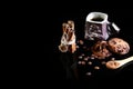 Close-up cup of espresso coffee, milk and cocoa spoon, round crunchy chocolate cookies with coffee beans, sticks of cinnamon on a