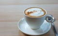 Close up a cup of cappuccino coffee on wooden table