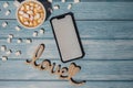 Close up of Cup hot chocolate marshmallows cacao Wooden decoration LOVE text. Cozy Coffee with marshmallows with mobile Royalty Free Stock Photo