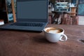 Close up of Cup of hot latte art coffee with laptop computer on wooden table, work with coffee concept picture foe business Royalty Free Stock Photo