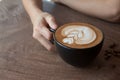 Close up of Cup of hot latte art coffee on wooden table Royalty Free Stock Photo