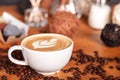 Cup of cappuccino with latte-art and cakes on a wooden table with scattered coffee beans. Presentation of coffee Royalty Free Stock Photo