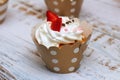 Close-up cupcakes with whipped eggs cream decorated fresh strawberry and chocolate balls on old white wooden table background Royalty Free Stock Photo