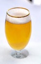 Close up of a cups of pilsner full of beer on snow Royalty Free Stock Photo