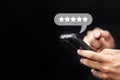 close up on customer man hand pressing on smartphone screen with gold five star rating feedback icon and press level excellent Royalty Free Stock Photo