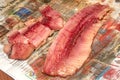 Cut herring on a wet old newspaper, close-up Royalty Free Stock Photo