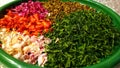 Close-up of cut leaves, orange, pink and white roses and ylang-ylang flowers on a green plate