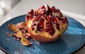 Close up of cut pomegranate in plate, fresh garnet background