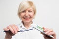 Close up and cut vuew of a woman putting some toothpaste on the toothbrush. She wants to clean her teeth. The lady is