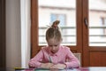 Blond hair school girl boring and tired looking down, sitting at the desk with school supplies Royalty Free Stock Photo