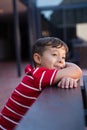 Close up of cute boy looking away while leaning on table Royalty Free Stock Photo