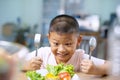 Happy child boy eating vegetables at home. Royalty Free Stock Photo