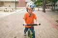 Asian toddler boy child wearing safety helmet learning to ride first balance bike on cement floor Royalty Free Stock Photo