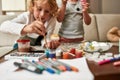 Close up of cute little boy painting colorful Easter eggs together wih his sibling sister while spending time at home Royalty Free Stock Photo